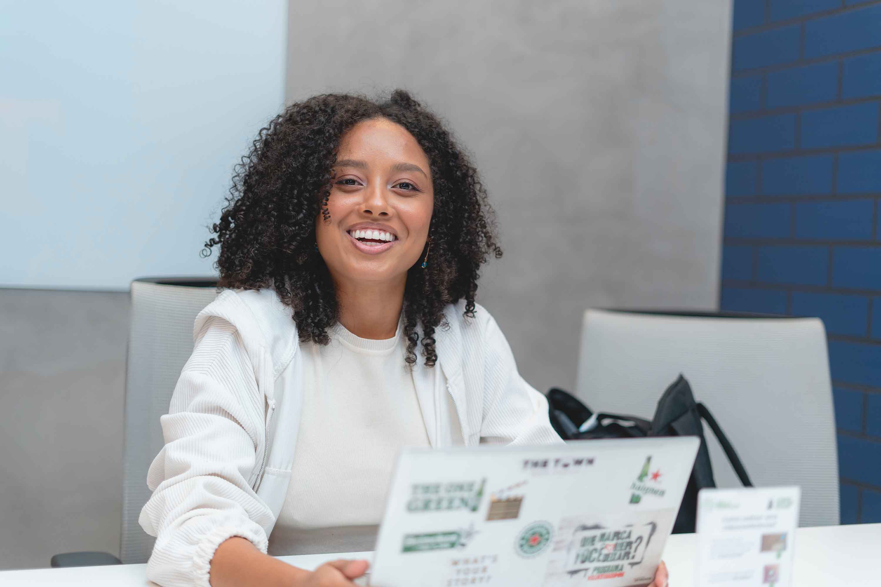 Mulher negra sorrindo segurando notebook